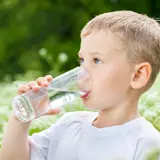 Dreng drikker et glas vand